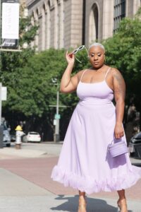 Dallas-based fashion influencer Kai Michelle poses in a pink midi dress