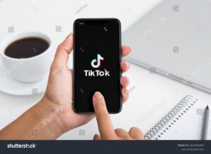 Hand holding TikTok app; affiliate marketing with TikTok
