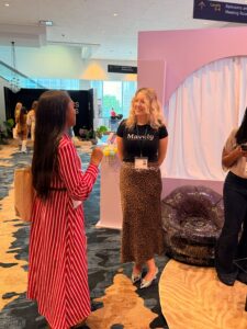 Sarah Adams, a Campaigns Enablement Manager at Mavely, networks with Mom 2.0 attendees at our Y2K-themed booth